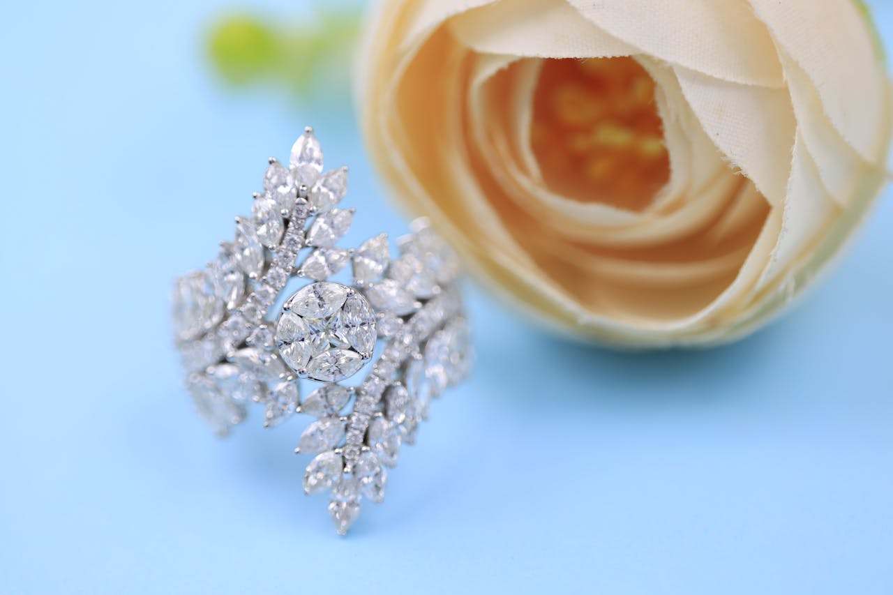 Sparkling diamond ring showcased on a pastel blue background with a delicate rose, perfect for fashion and jewelry themes.